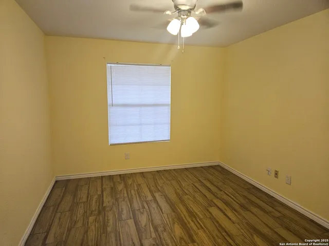 a view of a room with wooden floor and fan
