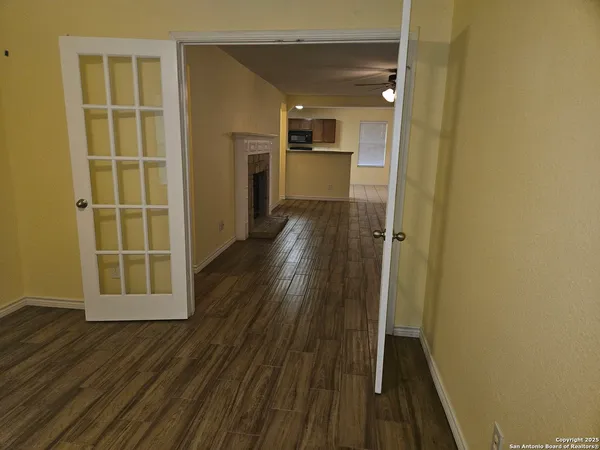 a view of a hallway with wooden floor and a cabinet