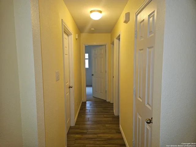 a view of a hallway with wooden floor