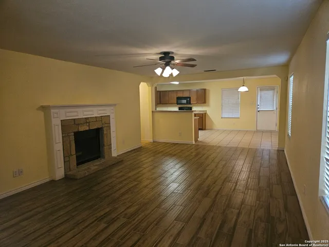 a view of a kitchen with a sink a fireplace and wooden floor