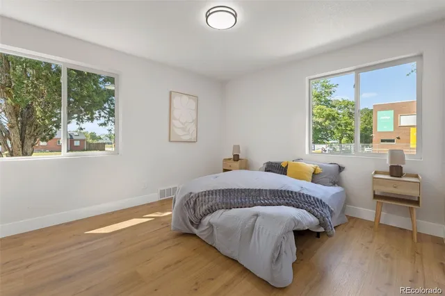 a bedroom with a bed and wooden floor