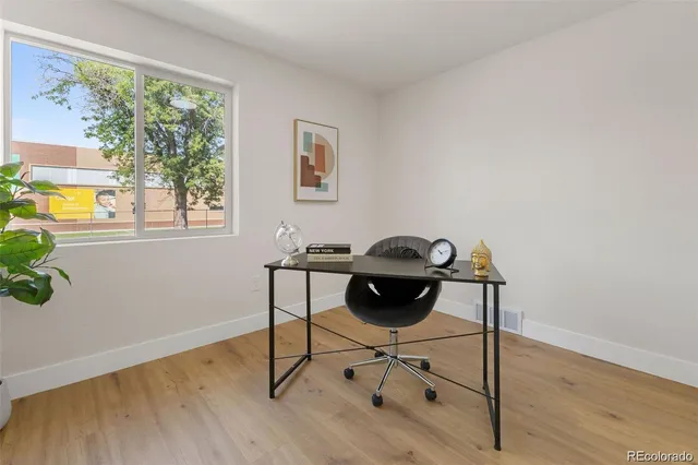 a view of a workspace with furniture and a window