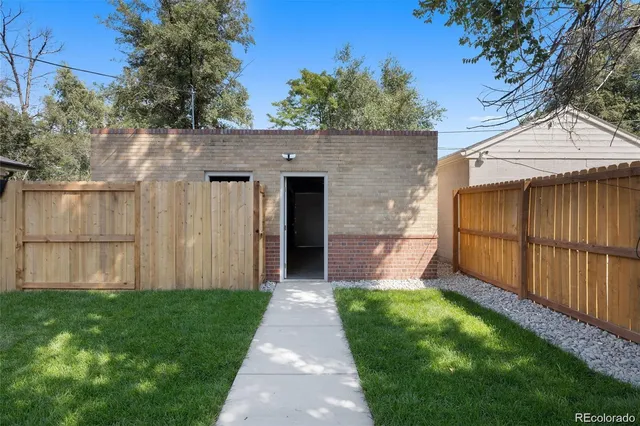 a view of a backyard with potted plants and large tree