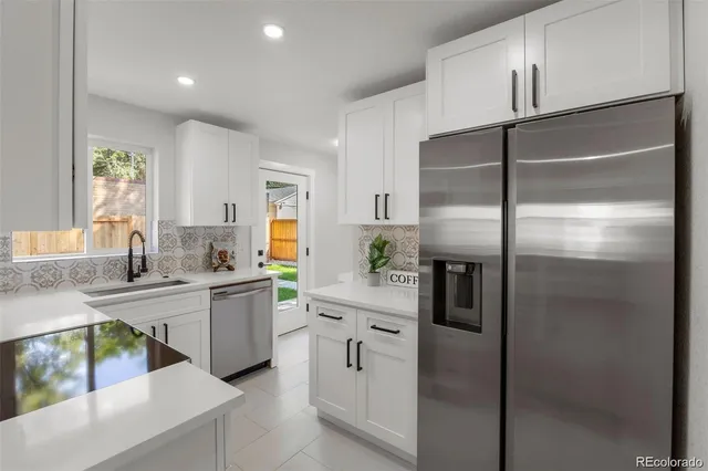 a kitchen with white cabinets and stainless steel appliances