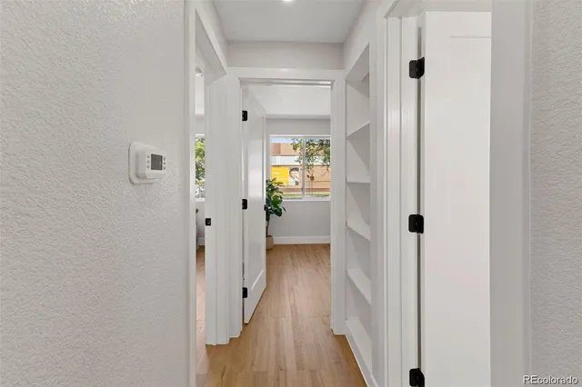 a view of a hallway with wooden floor and closet