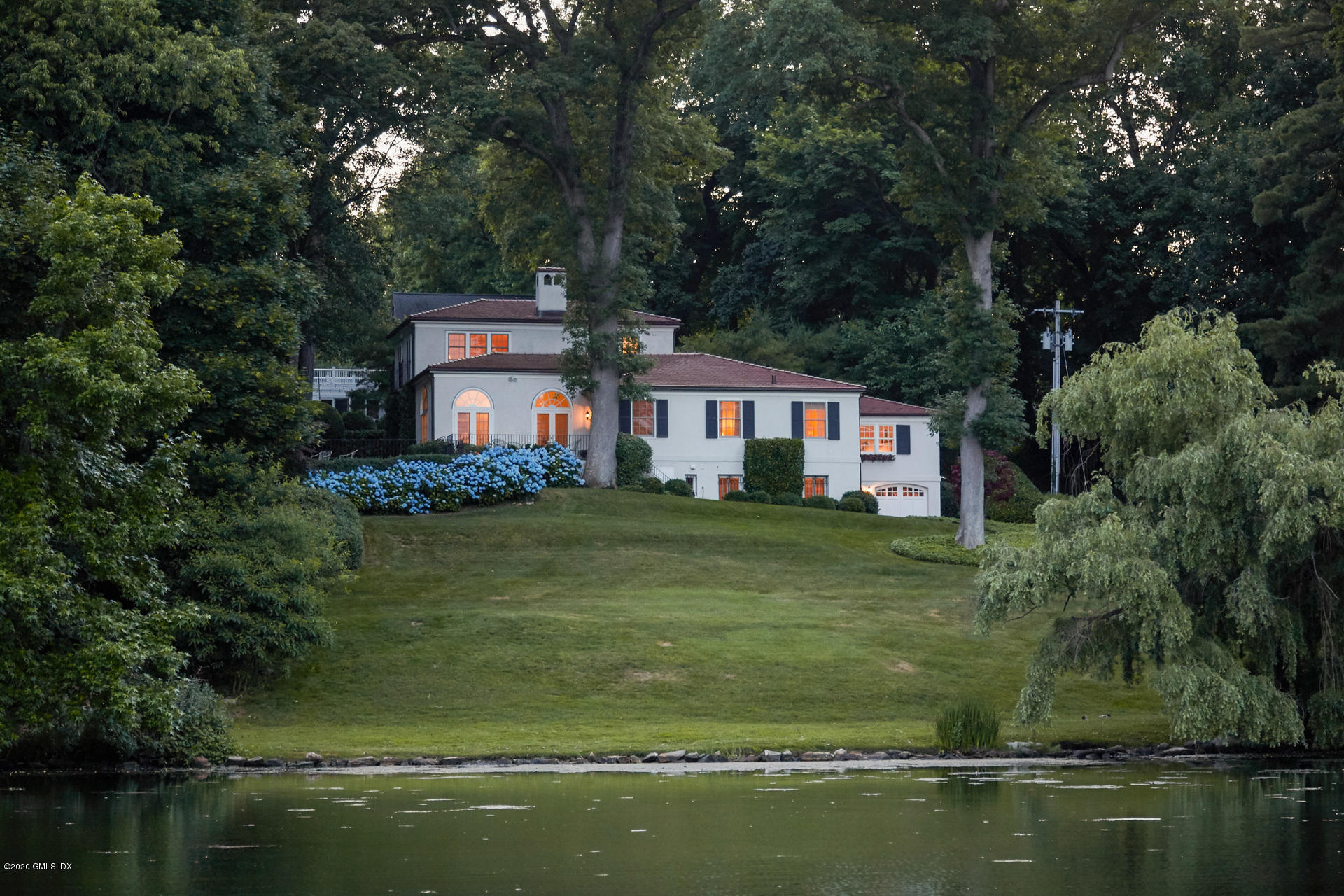 a view of a house with a yard next to a lake
