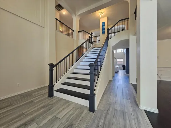 a view of a hallway with wooden floor and entryway