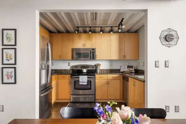a kitchen with stainless steel appliances a stove a refrigerator and a microwave