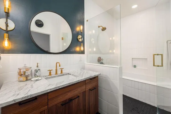 a bathroom with a granite countertop sink a mirror and vanity