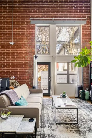 a living room with furniture a flat screen tv and a large window