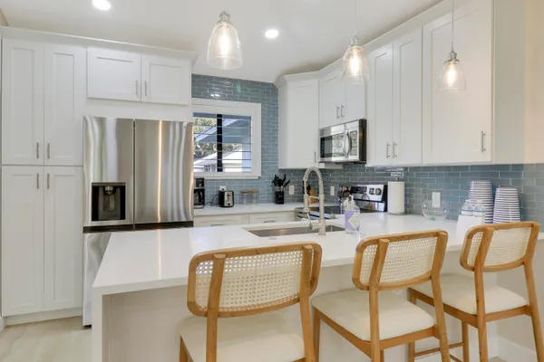 a kitchen with stainless steel appliances granite countertop a stove a sink and a refrigerator