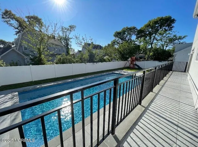 a balcony with wooden floor and yard in the back