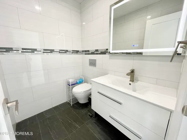 a bathroom with a sink a toilet and mirror