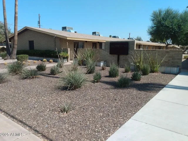 a view of a patio with table and chairs potted plants and a palm tree