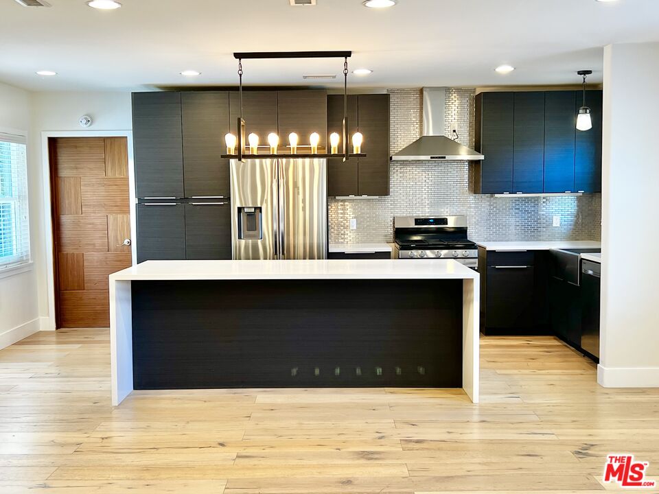 5757 Vesper Avenue Van Nuys, CA 91411 - Photo 6 of 26 a kitchen with kitchen island a sink stainless steel appliances and cabinets