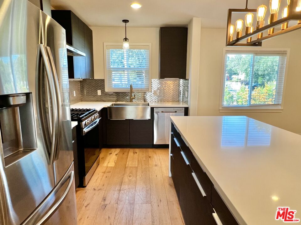 5757 Vesper Avenue Van Nuys, CA 91411 - Photo 7 of 26 a kitchen with stainless steel appliances granite countertop a sink stove and refrigerator