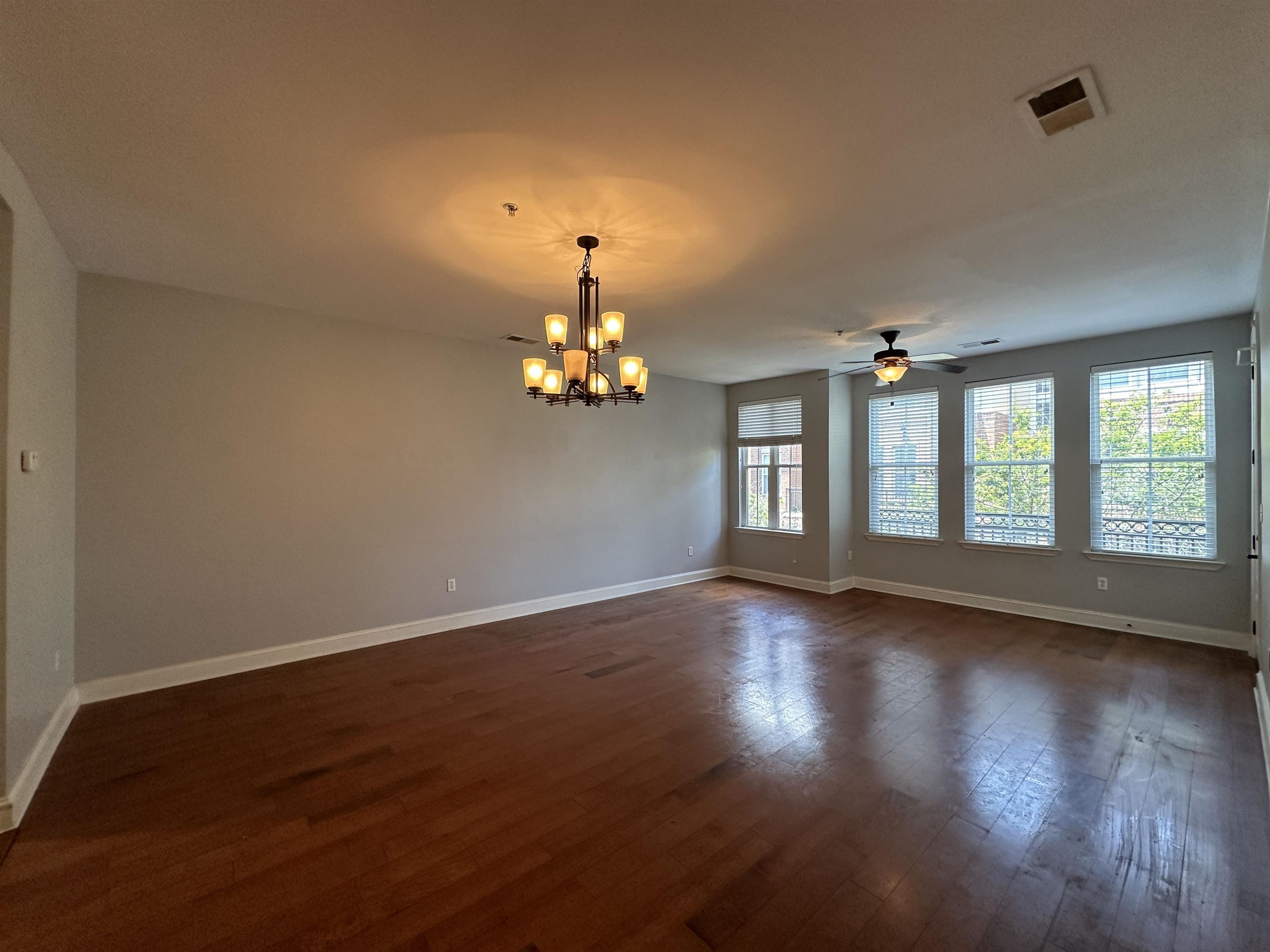 75 Shoemaker Court, Unit 304 Memphis, TN 38103 - Photo 3 of 25 Unfurnished room featuring a healthy amount of sunlight, dark hardwood / wood-style floors, and ceiling fan with notable chandelier