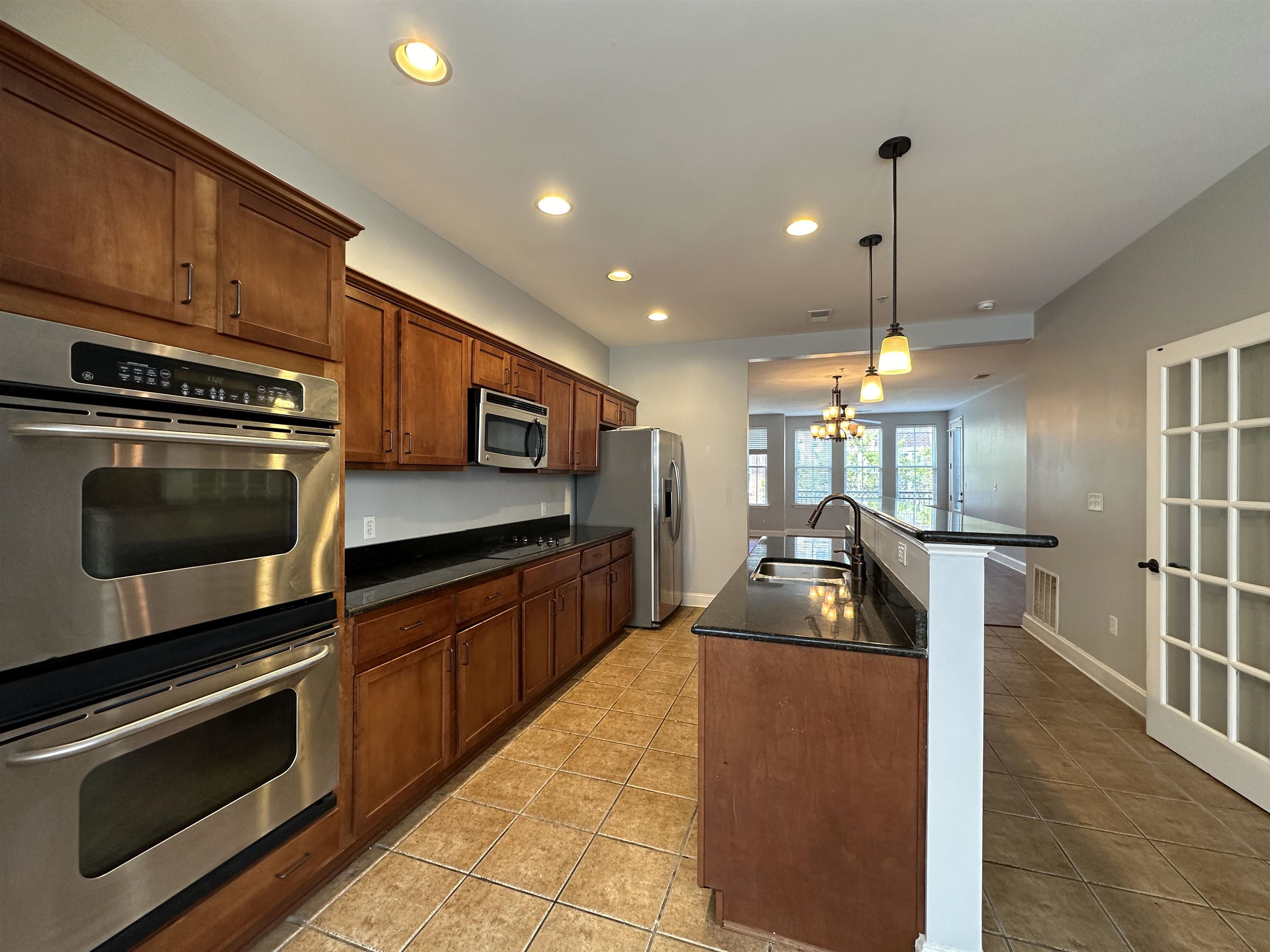 75 Shoemaker Court, Unit 304 Memphis, TN 38103 - Photo 5 of 25 Kitchen with stainless steel appliances, a notable chandelier, a center island with sink, hanging light fixtures, and sink
