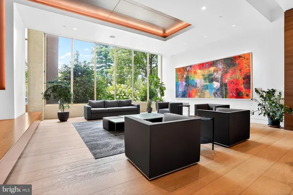 a living room with furniture a flat screen tv and a floor to ceiling window
