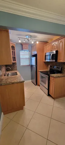 a kitchen with stainless steel appliances granite countertop a sink and a stove