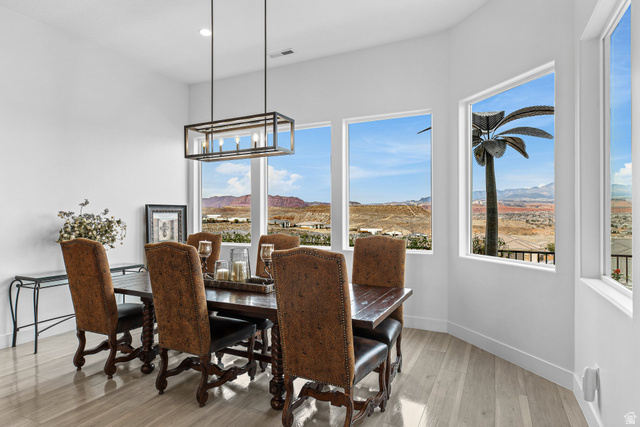 3022 West Sesia Way St. George, UT 84770 - Photo 22 of 52 Dining area with light wood-type flooring, a mountain view, and hanging lights
