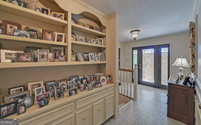 a spacious bedroom with a bed a chandelier and a dresser