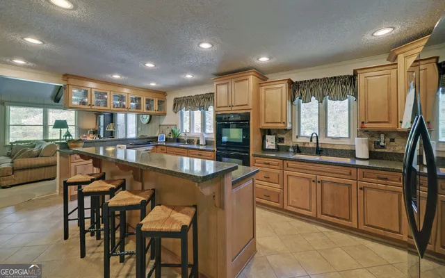 a kitchen with a sink a counter top space appliances and cabinets