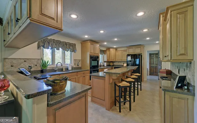 a kitchen with stainless steel appliances granite countertop a stove refrigerator and cabinets