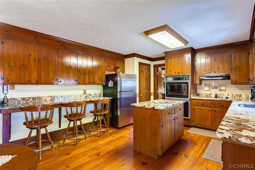 15210 Harrowgate Road Chester, VA 23831 - Photo 6 of 26 a kitchen with stainless steel appliances kitchen island granite countertop a table chairs and a refrigerator