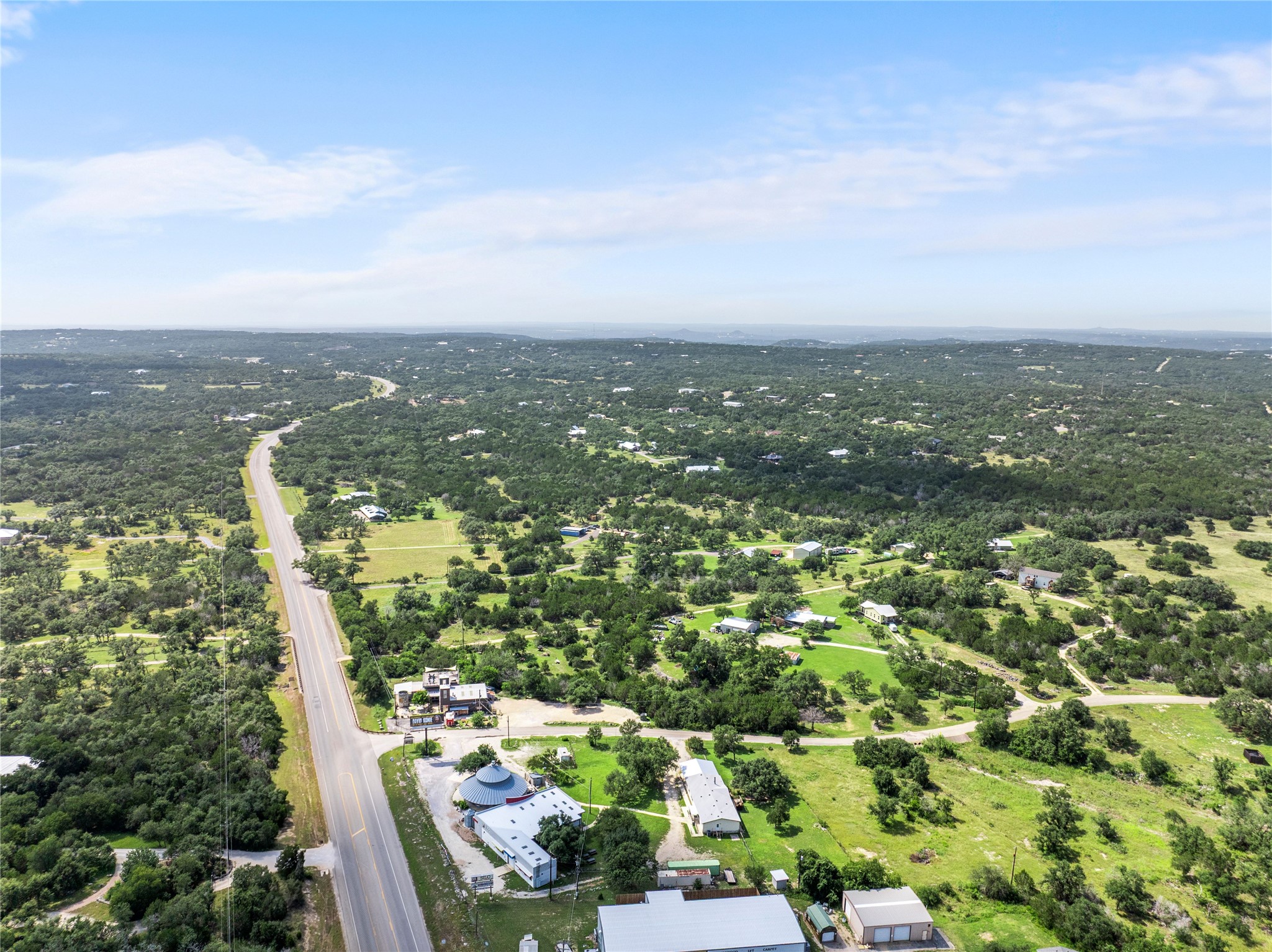 8200 Ranch Road 12 San Marcos, TX 78666 - Photo 39 of 40 Scenic aerial views showcase expansive green landscapes and a winding roadway through the countryside.