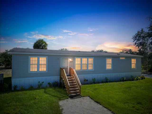 a front view of a house with a yard and outdoor seating