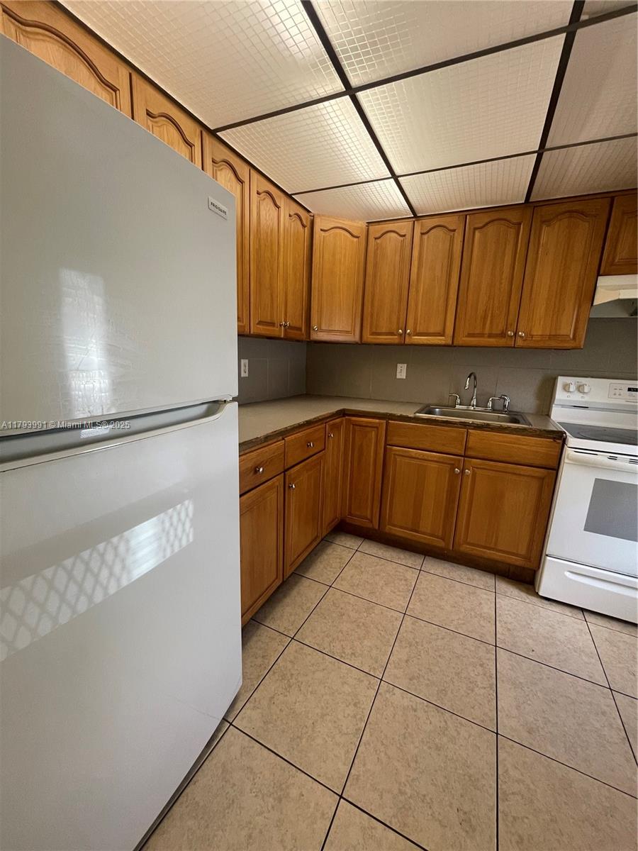 4200 Northwest 3rd Court, Unit 134 Plantation, FL 33317 - Photo 5 of 15 a kitchen with a sink a refrigerator and cabinets