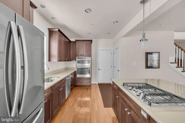 a kitchen with kitchen island granite countertop a refrigerator and a sink
