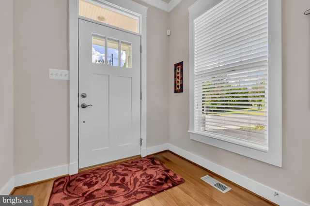 a view of a hallway with wooden floor and staircase