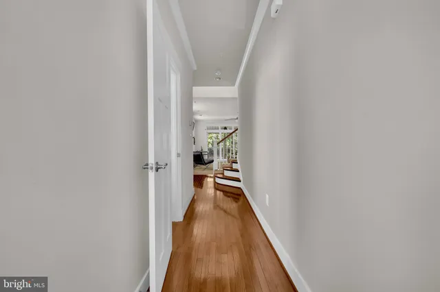 a view of a hallway with wooden floor and staircase