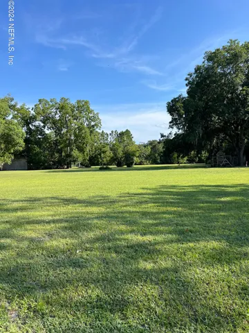 a view of a big yard with a house in the background