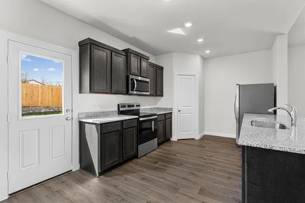 a kitchen with stainless steel appliances granite countertop a sink stove and refrigerator