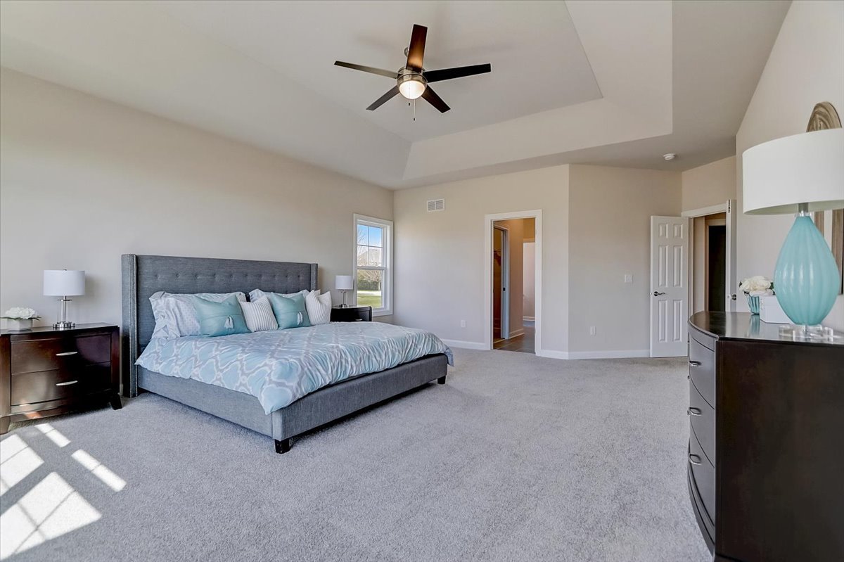 39-w553 Carl Sandburg Road St. Charles, IL 60175 - Photo 33 of 49 a spacious bedroom with a bed a dresser and a chandelier