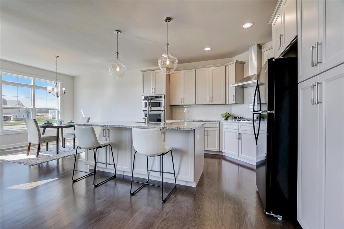39-w553 Carl Sandburg Road St. Charles, IL 60175 - Photo 10 of 49 a kitchen with stainless steel appliances granite countertop a refrigerator a microwave a stove and white cabinets with wooden floor