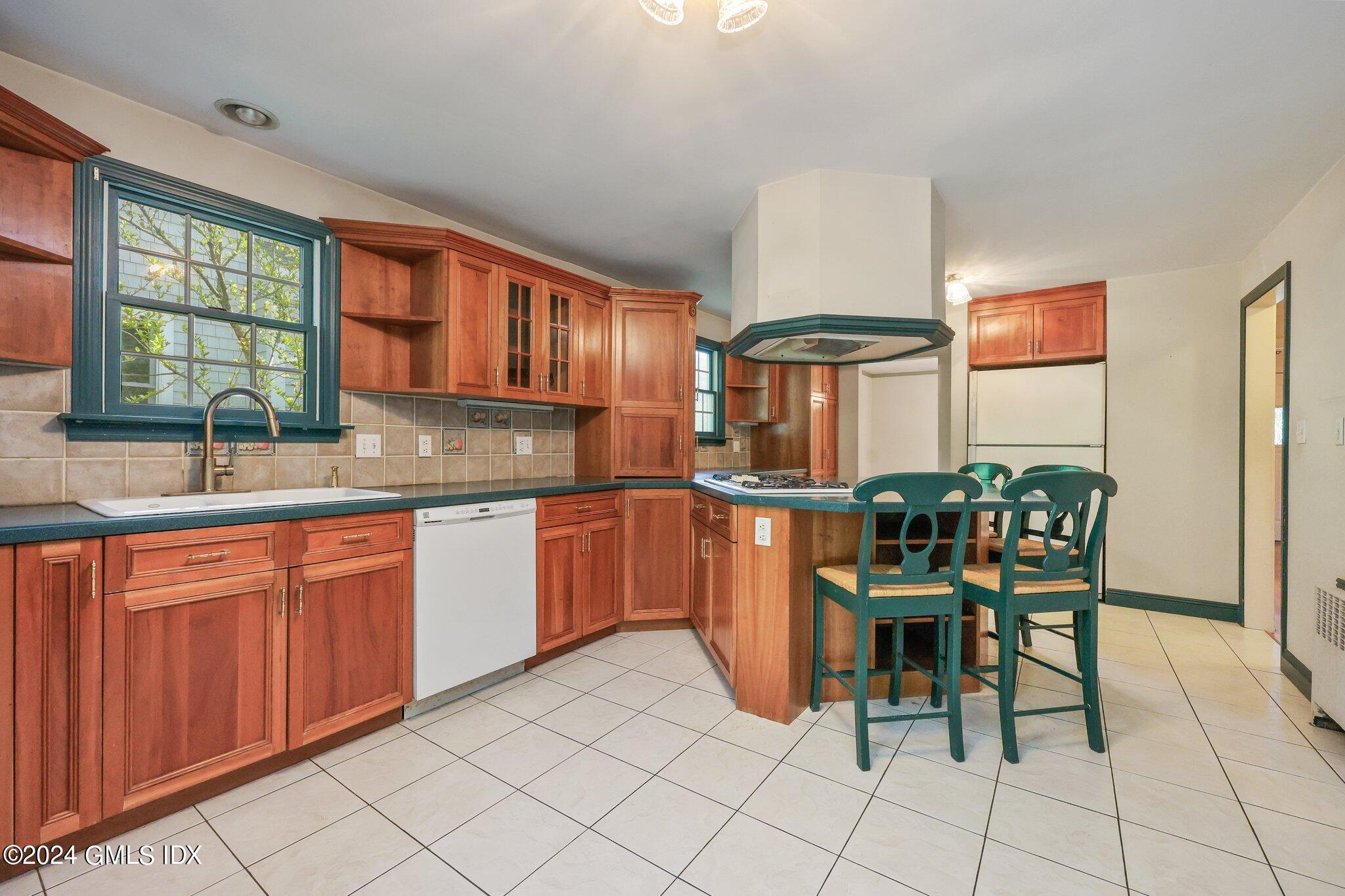 6 Center Road Old Greenwich, CT 06870 - Photo 13 of 47 a kitchen with stainless steel appliances granite countertop a stove a sink a table and chairs