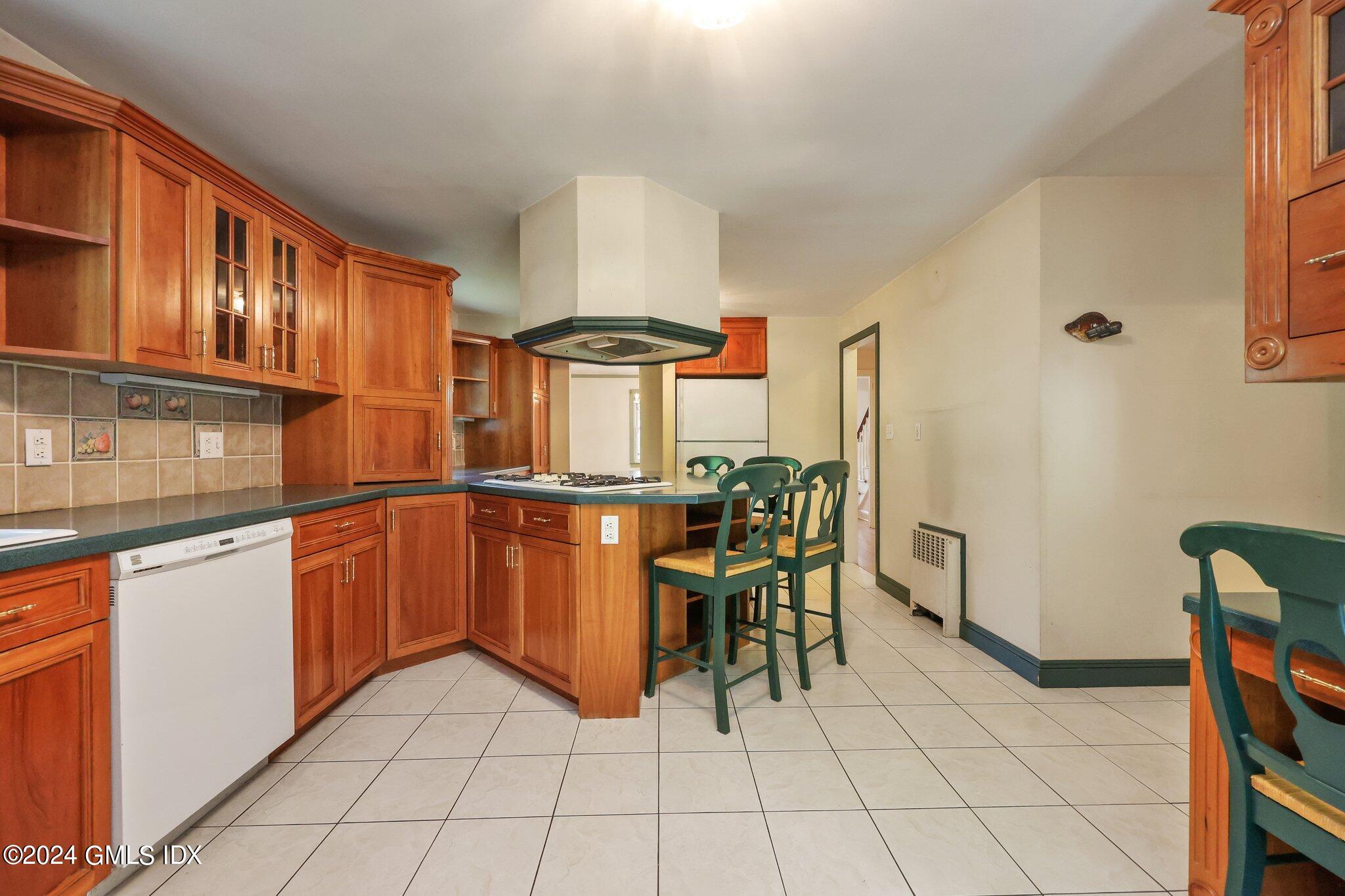 6 Center Road Old Greenwich, CT 06870 - Photo 14 of 47 a kitchen with granite countertop cabinets and chairs
