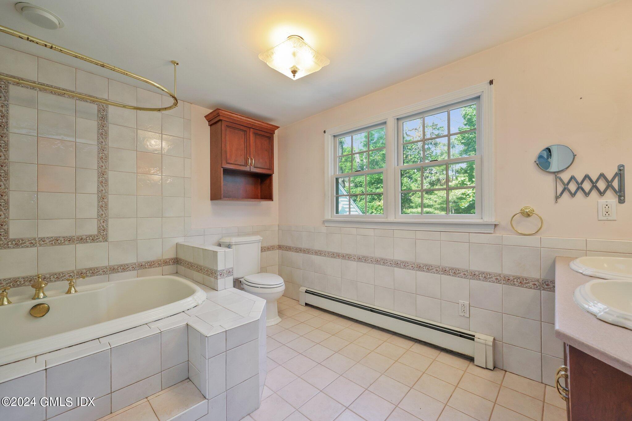6 Center Road Old Greenwich, CT 06870 - Photo 30 of 47 a bathroom with a tub a sink and a window