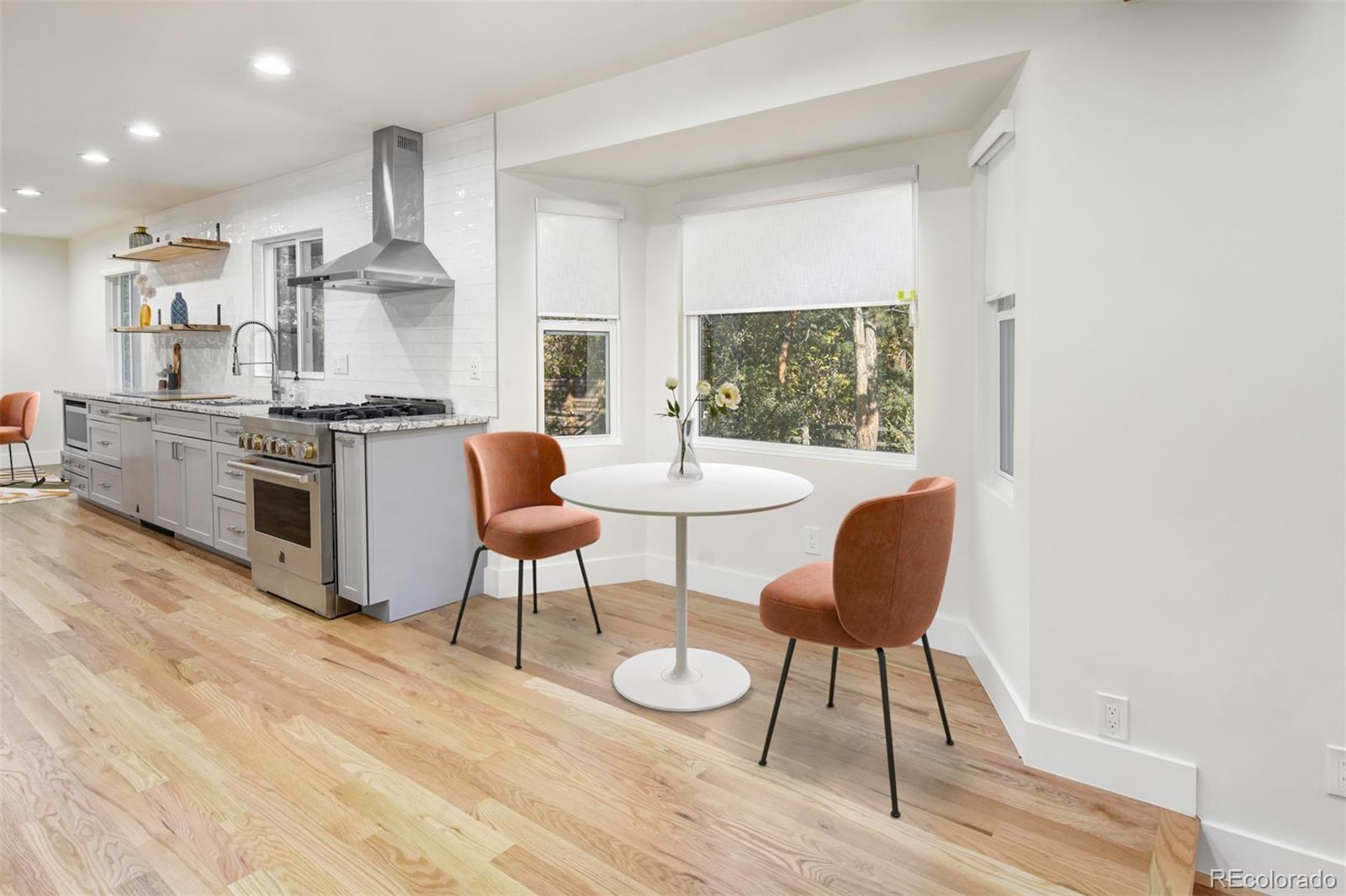 6107 Old Brompton Road Boulder, CO 80301 - Photo 13 of 40 a kitchen with stainless steel appliances granite countertop a stove top oven a dining table and chairs with wooden floor