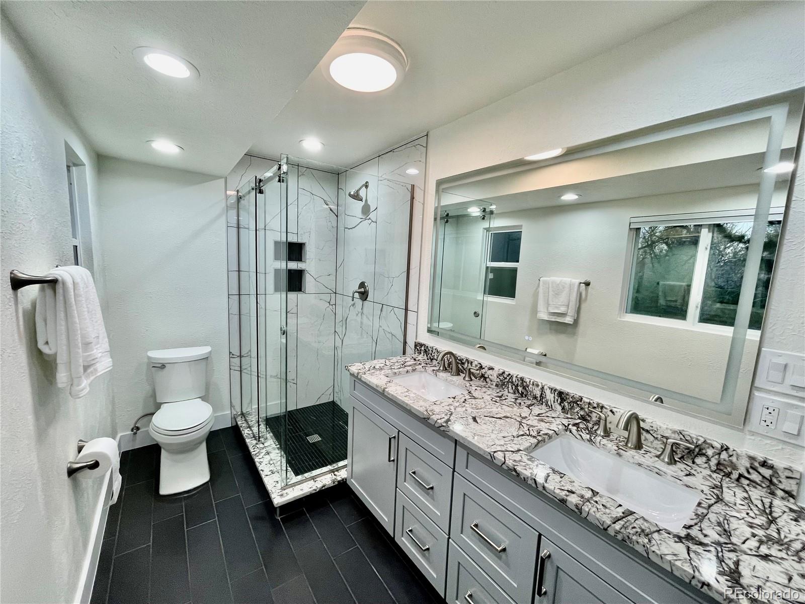 6107 Old Brompton Road Boulder, CO 80301 - Photo 17 of 40 a spacious bathroom with a double vanity sink toilet and shower