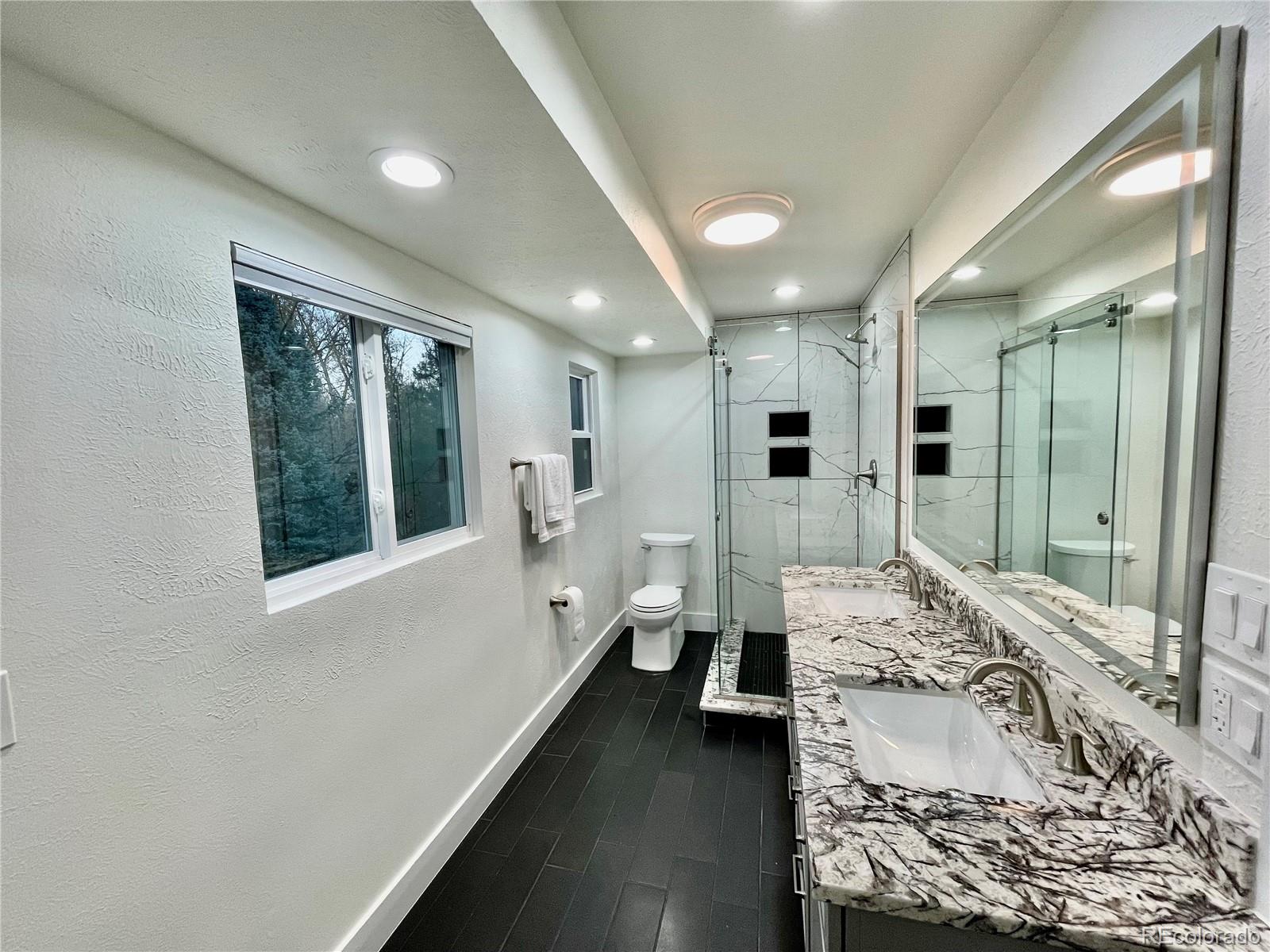 6107 Old Brompton Road Boulder, CO 80301 - Photo 18 of 40 a bathroom with a double vanity sink toilet and shower