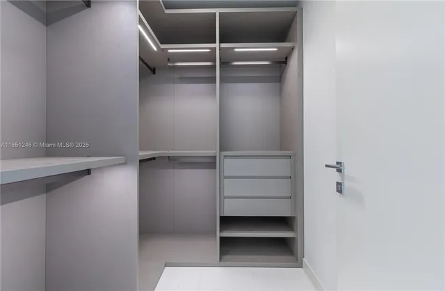 a bedroom with a large bed couch and a flat tv screen next to a window