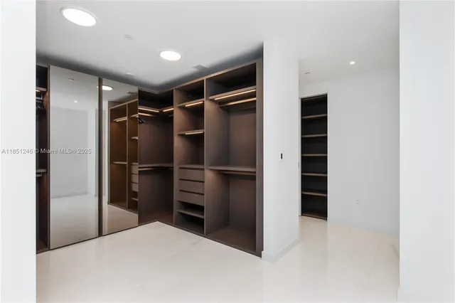 a view of walk in closet with clothes and shoes