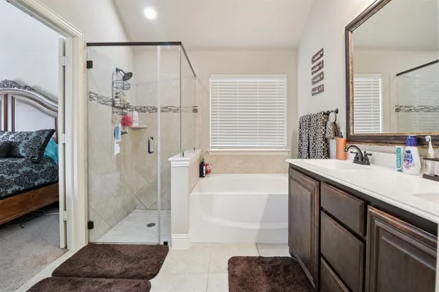 a bathroom with a tub shower sink vanity and a mirror