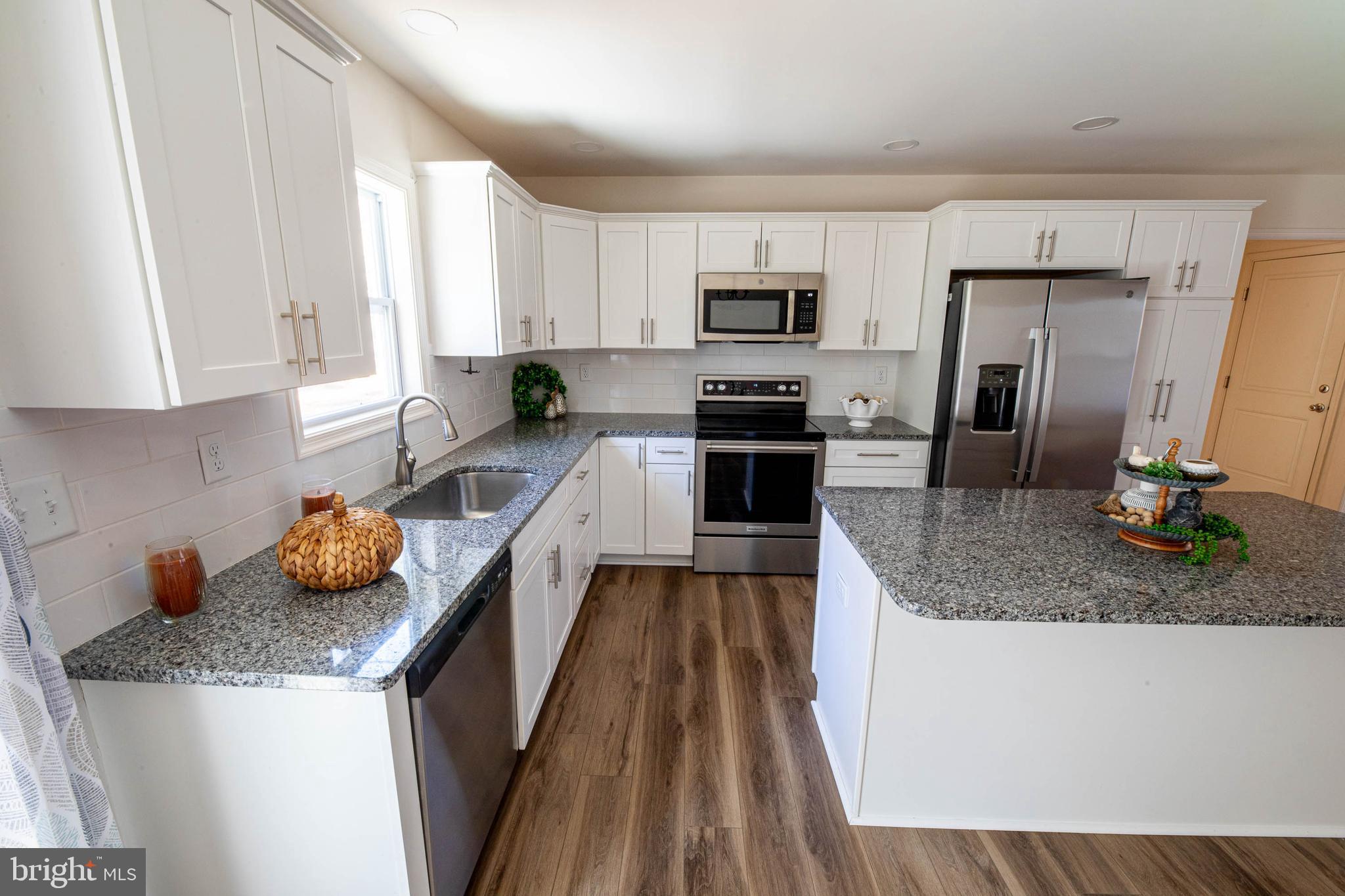 26300 Fire Tower Road Seaford, DE 19973 - Photo 12 of 52 a kitchen with granite countertop a sink counter top space appliances and cabinets