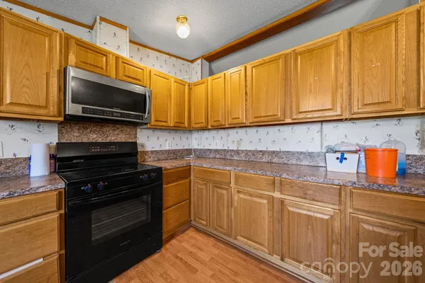 a kitchen with stainless steel appliances granite countertop a stove top oven a sink dishwasher and cabinets with wooden floor